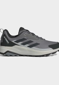 Gray Adidas Terrex trail running shoe with black stripes, black accents, and a textured sole for outdoor use.