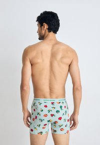 Herren Boxershorts in Hellblau mit einem floralen Muster. Dehnbarem Stoff mit einem grünen elastischen Bund, der den Markennamen "BJÖRN BORG" wiederholt.