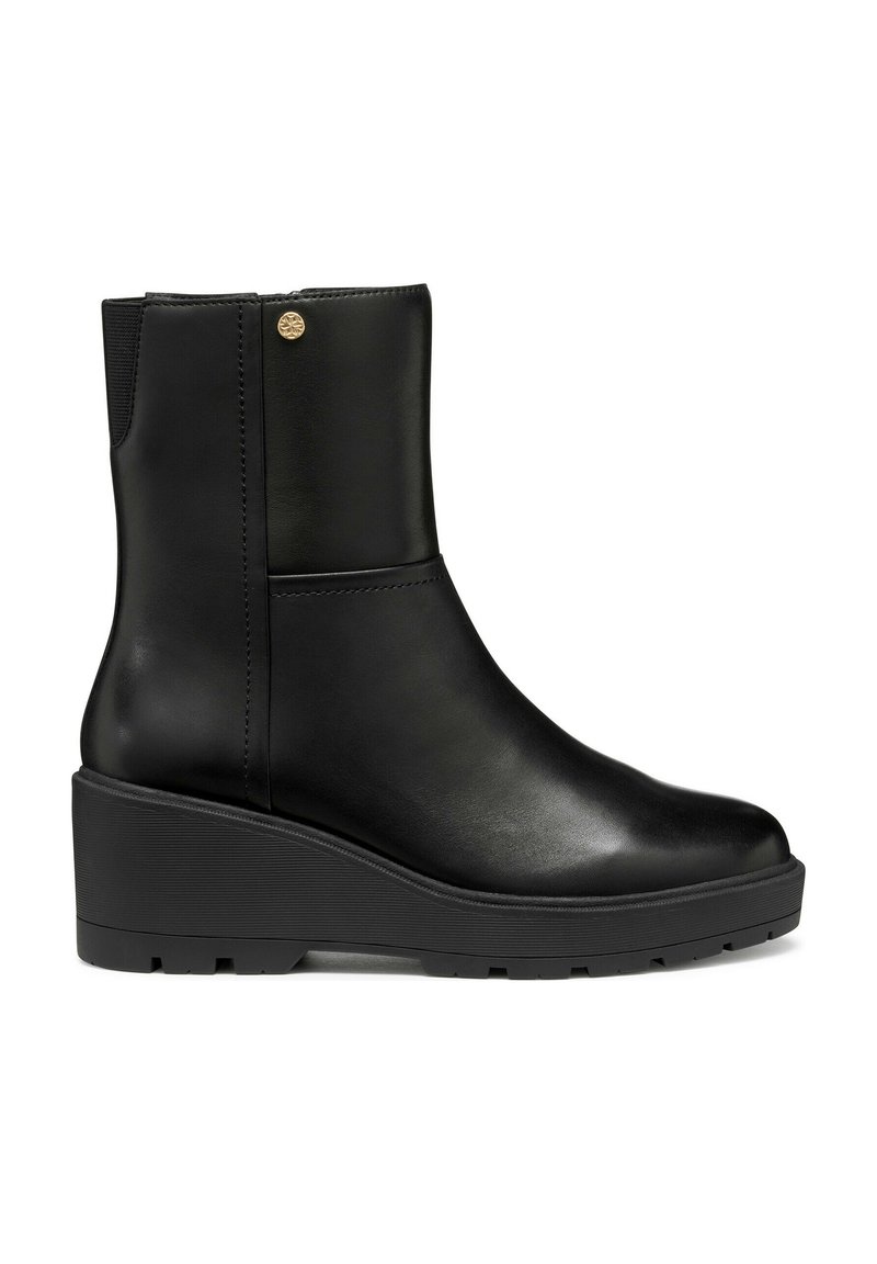 Bottine en cuir noir avec une finition lisse, bout arrondi et panneau élastique. Elle présente une semelle compensée basse et un accent logo doré.