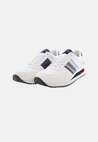 Scarpe sportive bianche con accenti blu navy; materiali in rete e sintetici; stringhe; suola in gomma con battistrada testurizzato per una buona aderenza; dettagli del logo e delle strisce laterali.