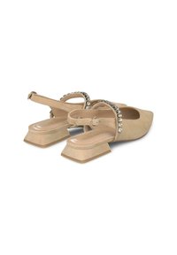 Chaussures slingback en suède beige avec un bout carré, un petit talon carré et une bride ornée de rhinestones transparents.