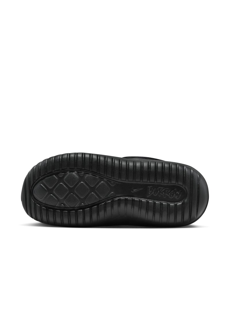 Suela de zapatilla negra con una superficie de goma texturizada que presenta un patrón de diamantes, estrías elevadas y detalles del logotipo en relieve.