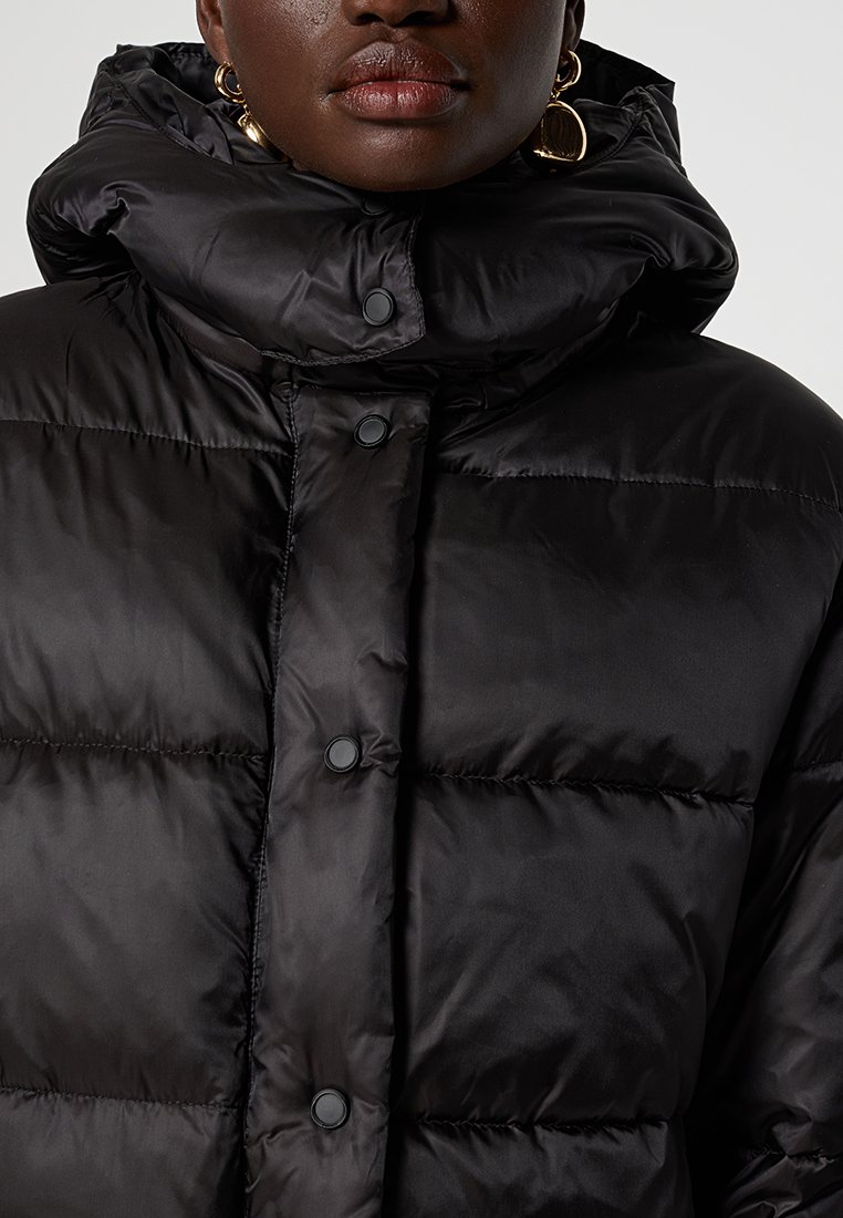 Schwarze Daunenjacke mit hohem Kragen, Druckknöpfen vorne und einer glatten, glänzenden Textur. Mit Kapuze und gesteppter Optik.