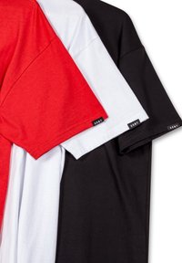 Tres camisetas apiladas: roja, blanca y negra. Hechas de una tela suave con mangas cortas, con pequeñas etiquetas de la marca en el dobladillo.