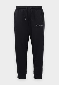  svarte joggebukser laget av mykt stoff med elastisk midje og snøring, med brodert logo og glidelåslommer.
