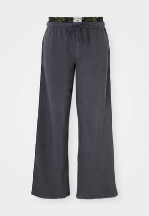 Dark gray wide-leg pants made of soft fabric with a green camo-patterned elastic waistband and drawstring. Features side pockets.