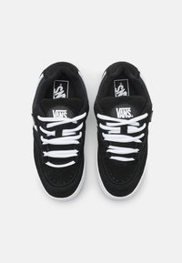 Black suede sneakers with white laces and contrasting white rubber sole. Features a black Vans logo on the tongue and side.