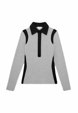 Haut gris à manches longues avec col noir, patte de boutonnage zippée verticale noire et panneaux d'accent noir sur les épaules et les côtés.