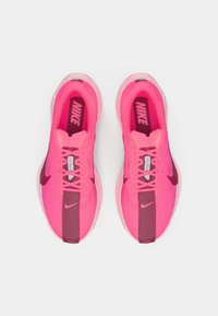 Violetit Nike-juoksukengät, joissa on verkkomateriaali, tekstuuripinnoitteet, harmaat korostukset sekä näkyvä brändäys kielekkeellä ja välipohjassa.