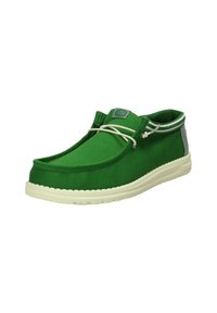 Scarpa in tela verde con punta arrotondata, suola in gomma bianca e pannelli grigi a contrasto. Presenta un design con lacci e un logo sulla linguetta.