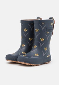 Bottes en caoutchouc bleu marine avec un motif floral jaune, semelle brown texturée et une sangle brown à l'arrière, avec un logo en relief sur le côté.