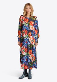 Langes Blumenkleid mit dunklem Hintergrund, das lebhafte rote, pinke und blaue Blumen zeigt. Lange Ärmel mit gerafften Bündchen und einem gestuften Rock.
