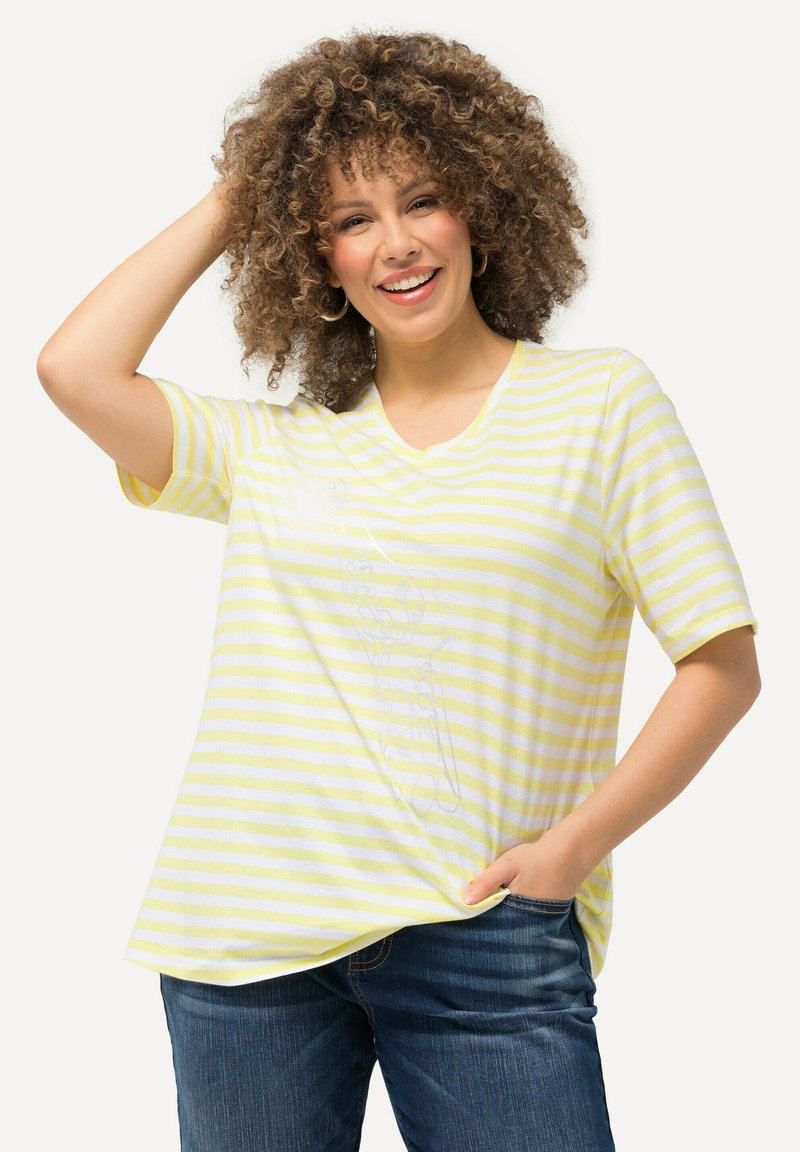 Camiseta a rayas amarilla y blanca con escote en V y mangas cortas, que presenta un corte holgado y un diseño impreso en la parte delantera.