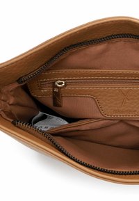 Interno di borsa in pelle color cuoio con una fodera in tessuto liscia, dotato di una tasca con cerniera e scomparti aperti per l'organizzazione.