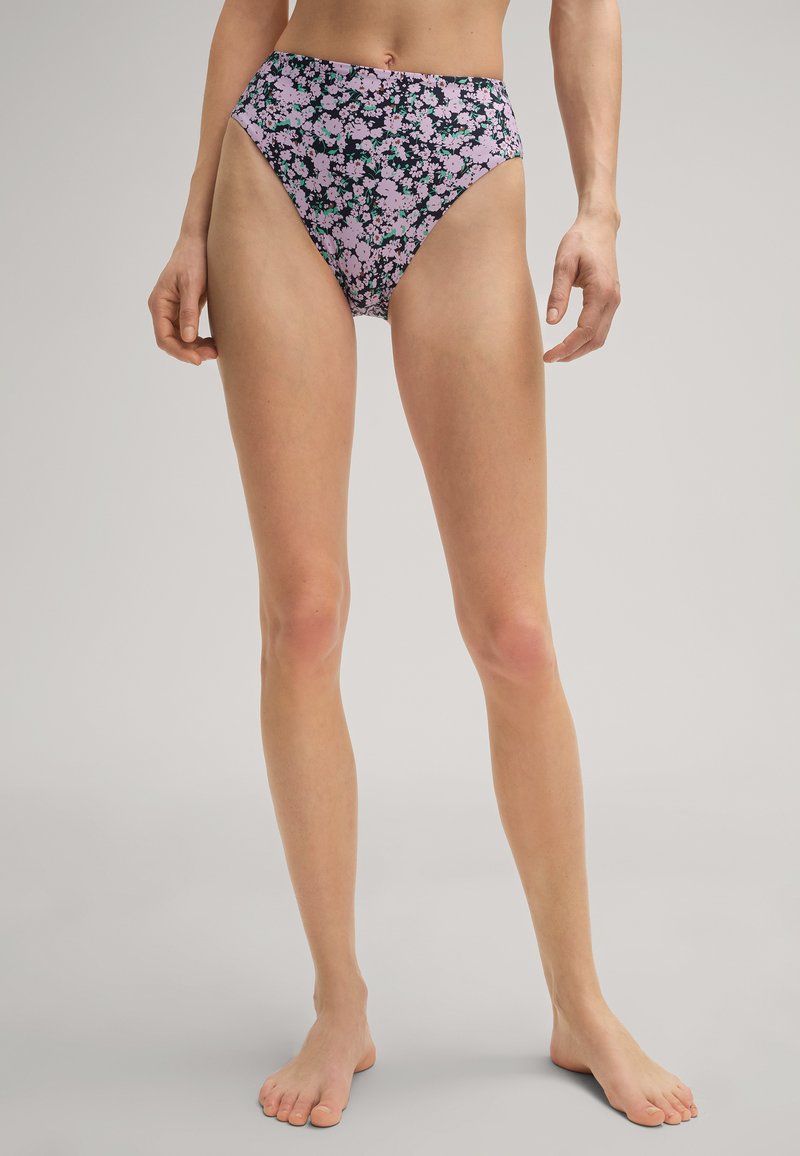 Bas de bikini taille haute sur fond sombre avec un motif floral rose et vert. Tissu extensible avec une texture lisse et sans matériel visible.