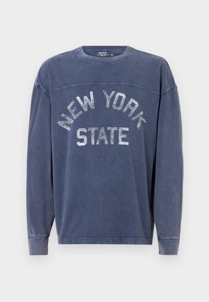 Sweatshirt de manga longa azul-marinho feito de tecido macio, com um gráfico texturizado em prata "NEW YORK STATE" abrangendo o peito.