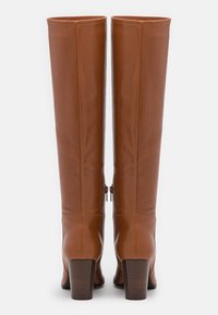 Brown leather knee-high boots with a square toe and block heel, featuring a smooth texture and two side zippers.