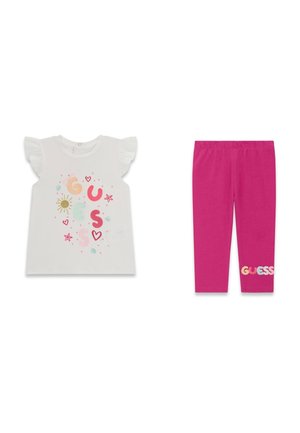 T-shirt blanc à manches volantées pour tout-petit avec logo coloré "GUESS" et soleil, associé à des leggings rose vif avec texte "GUESS" près de l'ourlet.