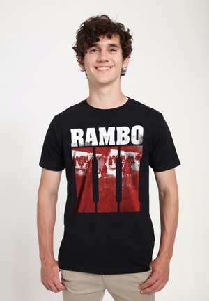 Sort bomulds t-shirt med et rødt grafik med "RAMBO" tekst og et billede af figurer, der viser et dristigt design og kontrast.