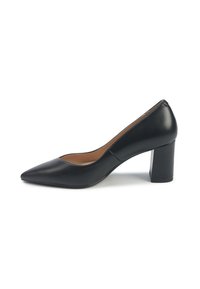 Pantofii negri din piele, cu vârful ascutit, ținând pe o talpă joasă și cu un finisaj neted, lucios, pe un fundal alb.