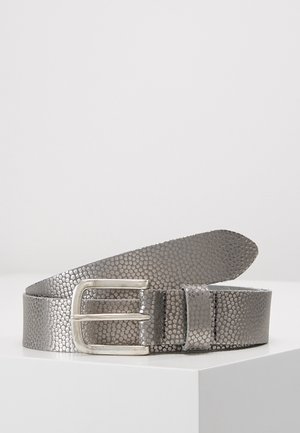 Šedý texturovaný kožený pásek se stříbrnou obdélníkovou sponou, stočený na bílém povrchu proti jednobarevnému pozadí.