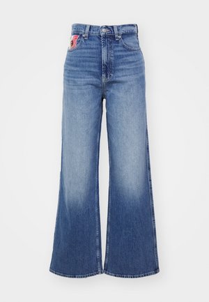 Vaqueros de tiro alto y pierna ancha, hechos de denim azul. Acabado desgastado con un bolsillo trasero como acento. Dobladillo sin rematar en la parte inferior, líneas limpias.