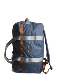 Navyblaue Reisetasche aus strapazierfähigem Gewebe. Mit silbernen und braunen Trägern, rechteckiger Form und einem Frontlabel mit Metallschmuck.