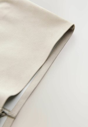 Tkanina v kremni barvi z mehko, gladko teksturo, rahlo zložena s čistim robom. Raven dizajn, minimalisticni videz.