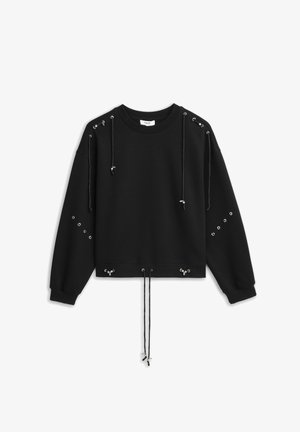 Schwarzer Pullover mit Metallösen und verstellbaren Kordeln an Schultern, Ärmeln und Saum, flach auf weißem Hintergrund liegend.