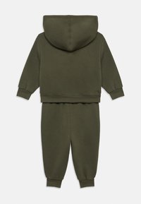 Σετ γκρι φούτερ με κουκούλα και παντελόνι φόρμας σε ελιά χρώμα, κατασκευασμένο από μαλακό, υφή βαμβάκι. Διαθέτει κουκούλα, ριμπ μανσέτες και ελαστική μέση στο παντελόνι.