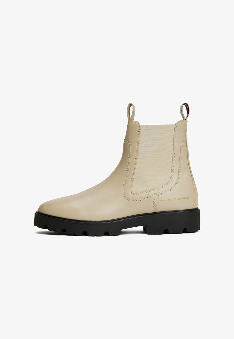 Stivaletto Chelsea in pelle beige con pannelli elastici laterali, linguette e suola in gomma nera robusta. Dettaglio logo discreto sul lato esterno.