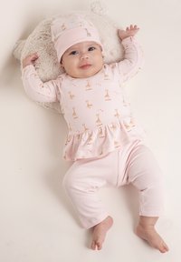 Outfit per neonati rosa con maniche lunghe, bordo peplum e motivo giraffa; berretto coordinato. Tessuto morbido e stretch, progettato per il comfort.