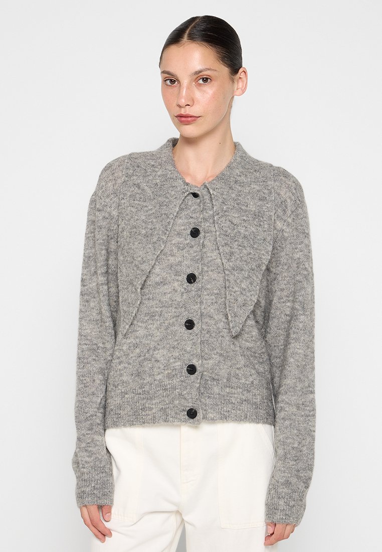 Szary sweter z dzianiny z zaokrąglonym kołnierzem, czarnymi guzikami i otwartą konstrukcją z przodu. Miękka tekstura i długie rękawy, z wykończeniem w stylu cropped.