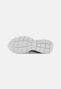 Rubber shoe sole in white with textured grid pattern. Features raised sections for traction and a smooth rounded toe design.