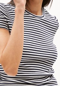 Randig topp i marinblått och vitt, med ribbad textur, korta ärmar och rund halslinning med kontrasterande trim.