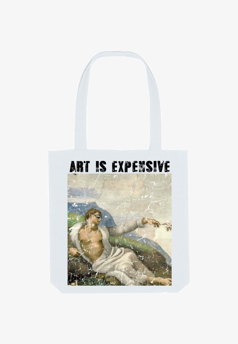 Witte canvas draagtas met een gebroken afbeelding van een gespierd figuur in een witte robe met zonnebril, omringd door een berglandschap.