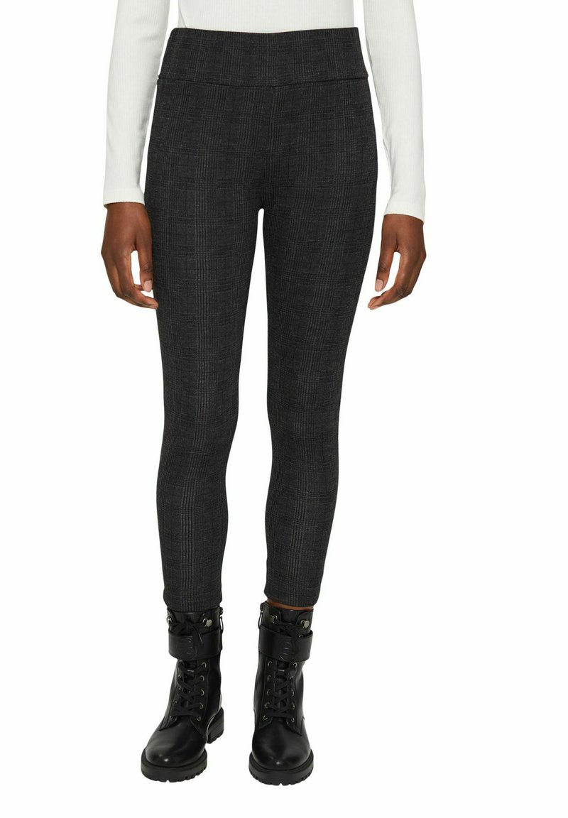 Leggings a quadri neri realizzati in tessuto elasticizzato, con una vita alta e una vestibilità slim. Abbinati a stivaletti neri.