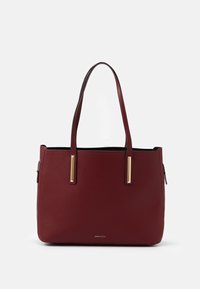 Burgundská kožená taška přes rameno s dvojitými popruhy, zlatými obdélníkovými akcenty a malým logem značky umístěným ve spodní části.