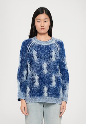 Overdimensjonert strikkegenser i gradient blå nyanser, med diamantmønster og ribbete mansjetter. Laget av myk, teksturert garn.