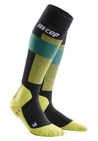 Calze a compressione realizzate in tessuto nero con accenti verdi e gialli. Design testurizzato e punta e tallone imbottiti per un supporto ottimale.