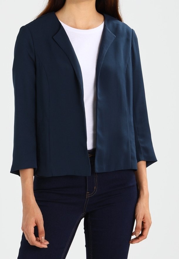 Navyblauw cropped blazer met een zachte, satijnen afwerking, een getailleerd ontwerp, met steekrevers en driekwart mouwen, gecombineerd met een witte top.
