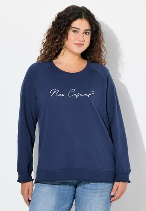Felpa blu navy con maniche lunghe, scollatura rotonda e scritta "New Casual". Presenta un orlo sfrangiato e una texture morbida.