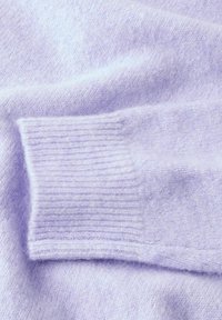 Ljust lila cashmeretröja med detalj av ribbad mudd, mjuk textur och slät yta, med en subtil glans.
