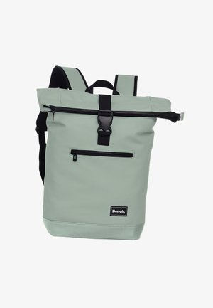 Sac à dos à rabat vert en tissu durable. Doté de fermetures éclair noires, de bretelles ajustables et d'une poche avant. Logo de la marque affiché.