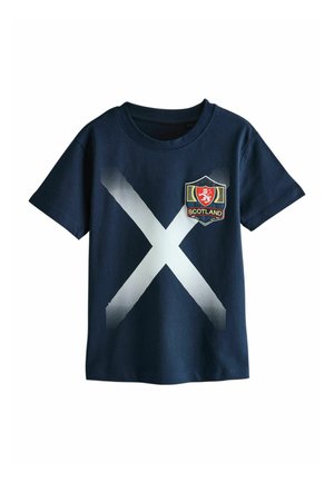 Tmavomodré tričko s veľkým bielym svätoandrejským krížom a nášivkou so znakom Škótska na ľavej strane hrude.