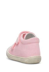 Pink canvas shoe with a textured surface and a white rubber sole. Features a Velcro strap on the back for easy wear.