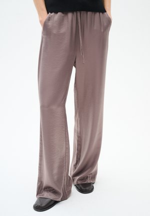 Lightweight, lavender satin wide-leg trousers with an elastic waistband, drawstring detail, and dual side pockets. Smooth texture.