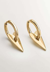 Pendientes en tono dorado con un diseño puntiagudo, acabado liso y brillante, y un aro circular para la sujeción.