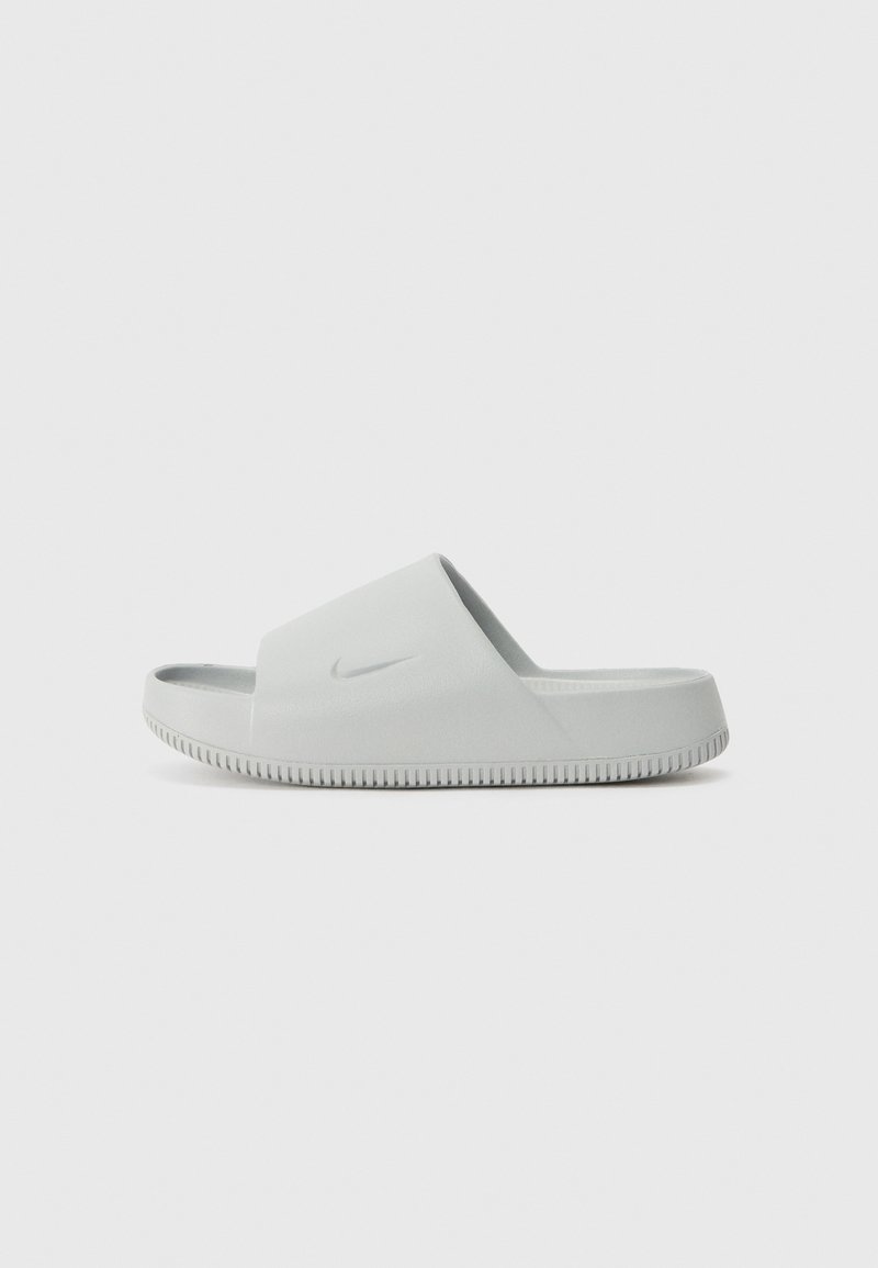 Light grey slide sandals featuring a smooth synthetic upper, open toe design, textured sole, and a small logo detail on the strap.