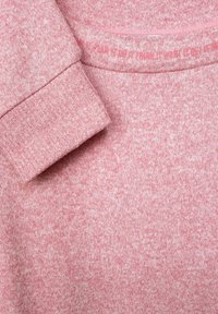 Różowy sweter z dzianiny o teksturowanym wzorze, z mankietem na rękawie i kontrastującym wewnętrznym kołnierzem. Miękki i lekki materiał.